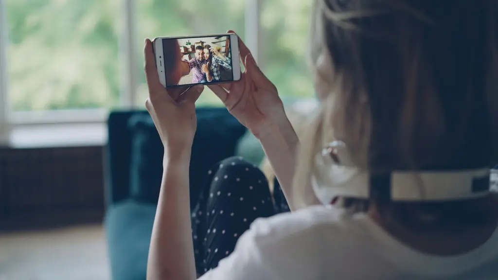 Persona en casa sosteniendo su celular durante una videollamada